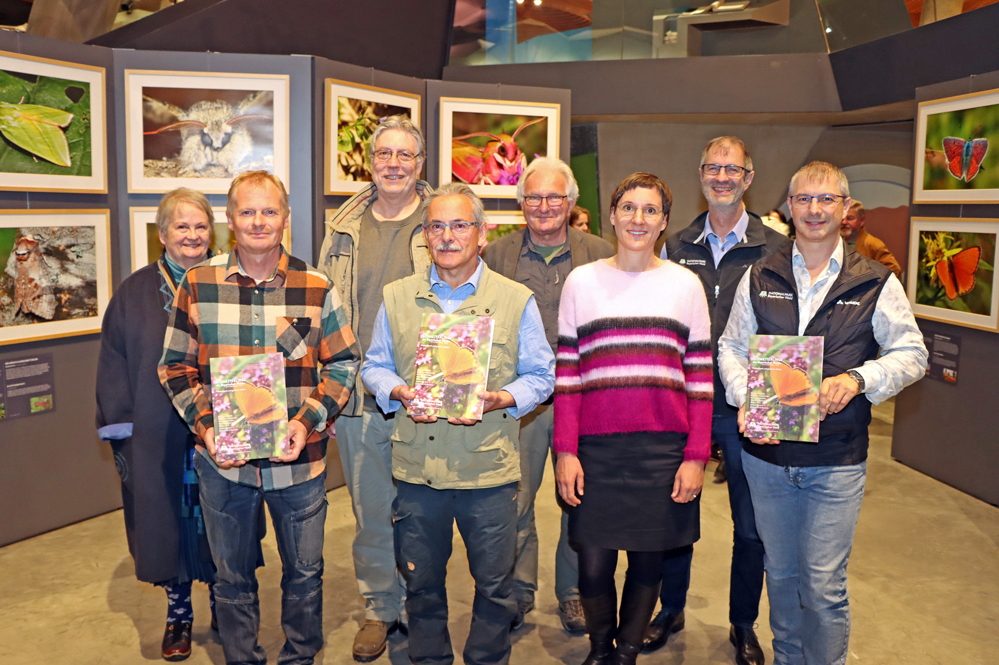 
Die Macher des Schmetterlingsbands mit Nationalparkleiterin Ursula Schuster (3.v.r.) inmitten der beeindruckenden Fotos der mittlerweile zu Ende gegangenen Ausstellung im Haus zur Wildnis. (Foto: Gregor Wolf / Nationalpark Bayerischer Wald)