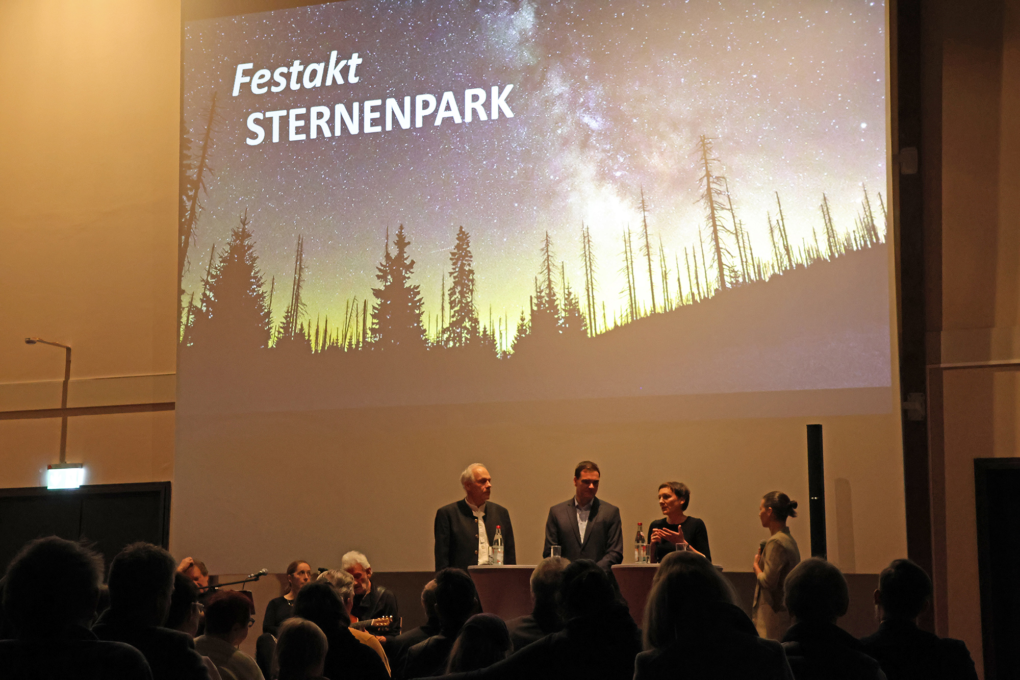 Naturpark-Geschäftsführer Hartwig Löfflmann (von links), Freyung-Grafenaus Landrat Sebastian Gruber und Nationalparkleiterin Ursula Schuster mit Moderatorin Julia Reihofer bei der Diskussionsrunde zur Sternenpark-Auszeichnung. (Foto: Gregor Wolf / Nationalpark Bayerischer Wald) Naturpark-Geschäftsführer Hartwig Löfflmann (von links), Freyung-Grafenaus Landrat Sebastian Gruber und Nationalparkleiterin Ursula Schuster mit Moderatorin Julia Reihofer bei der Diskussionsrunde zur Sternenpark-Auszeichnung. (Foto: Gregor Wolf / Nationalpark Bayerischer Wald)
